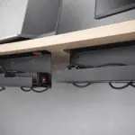 Bandeja slim bajo escritorio con regleta y cables ordenados; opción adhesiva y atornillada para home office.